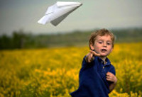 boy throwing paper airplane